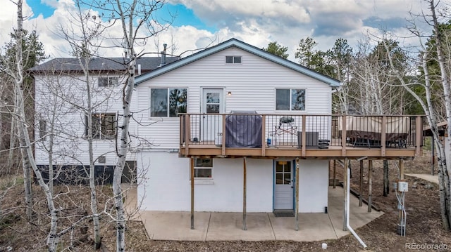 back of house with a deck and a patio