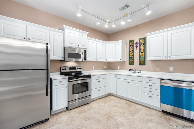 kitchen featuring sink, stainless steel appliances, and white cabinets