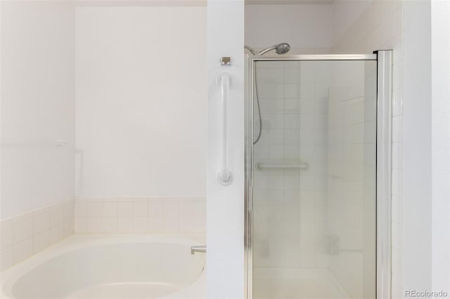 bathroom featuring shower with separate bathtub