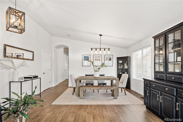 dining area with vaulted ceiling and hardwood / wood-style flooring