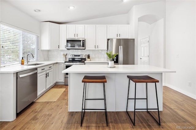 kitchen featuring backsplash, a center island, sink, and appliances with stainless steel finishes