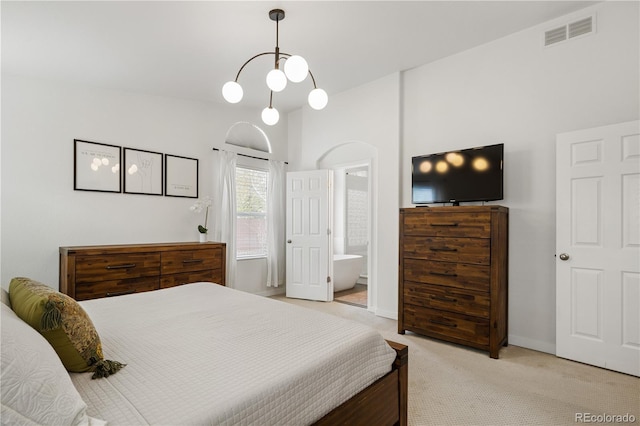 bedroom featuring light carpet and ensuite bathroom