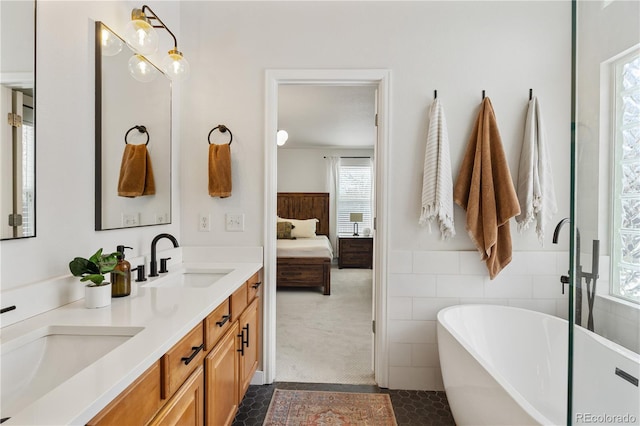 bathroom with tile patterned flooring, vanity, tile walls, and a bathing tub