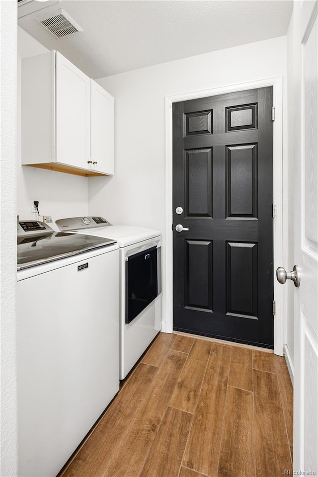 laundry area with cabinets and separate washer and dryer