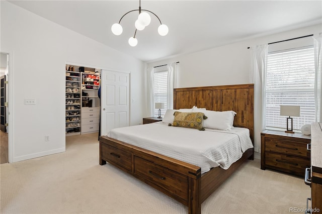 bedroom featuring vaulted ceiling, a walk in closet, multiple windows, and a closet