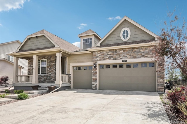 27196 E Alder Dr, Aurora, CO 80016 - view of front of house with stone siding, an attached garage, covered porch, driveway, and roof with shingles