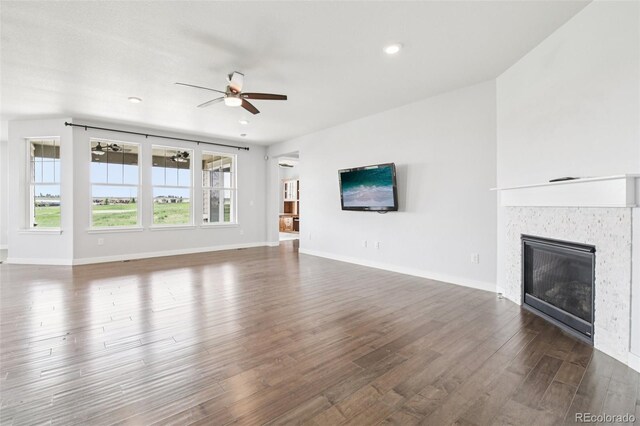 27196 E Alder Dr, Aurora, CO 80016 - unfurnished living room with ceiling fan, a glass covered fireplace, wood finished floors, and recessed lighting