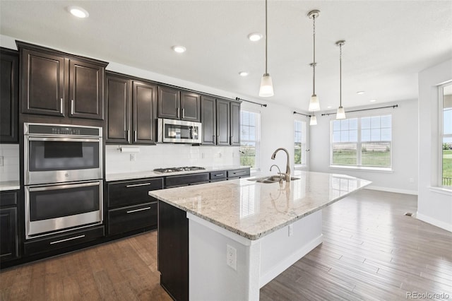 27196 E Alder Dr, Aurora, CO 80016 - kitchen featuring stainless steel appliances, dark wood-style floors, tasteful backsplash, recessed lighting, and an island with sink