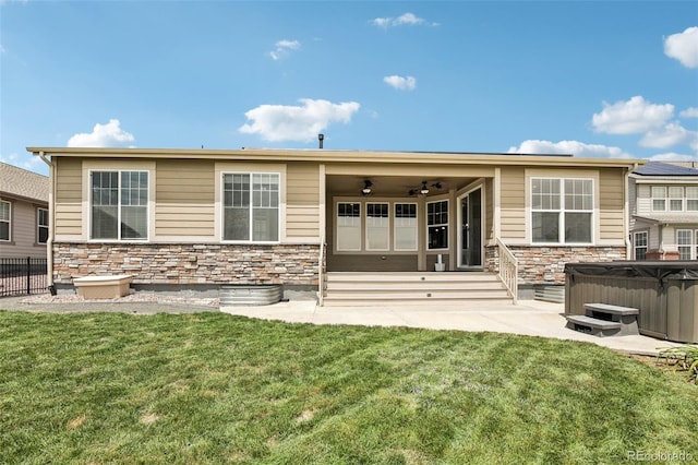 27196 E Alder Dr, Aurora, CO 80016 - back of house featuring a hot tub, stone siding, a ceiling fan, and a patio area