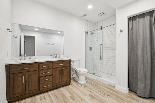 27196 E Alder Dr, Aurora, CO 80016 - bathroom featuring a shower stall, double vanity, wood finished floors, and recessed lighting