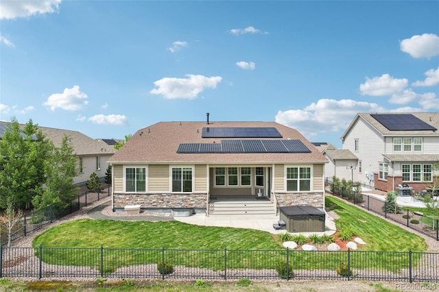 27196 E Alder Dr, Aurora, CO 80016 - rear view of house featuring stone siding, roof mounted solar panels, a patio, and a fenced backyard