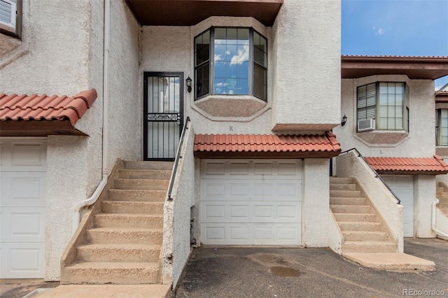 2620 S Federal Blvd Unit K, Denver, CO 80219 - view of exterior entry with stucco siding, a tiled roof, and cooling unit