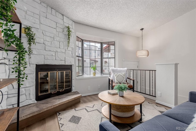2620 S Federal Blvd Unit K, Denver, CO 80219 - living area with a textured ceiling, wood finished floors, and a stone fireplace