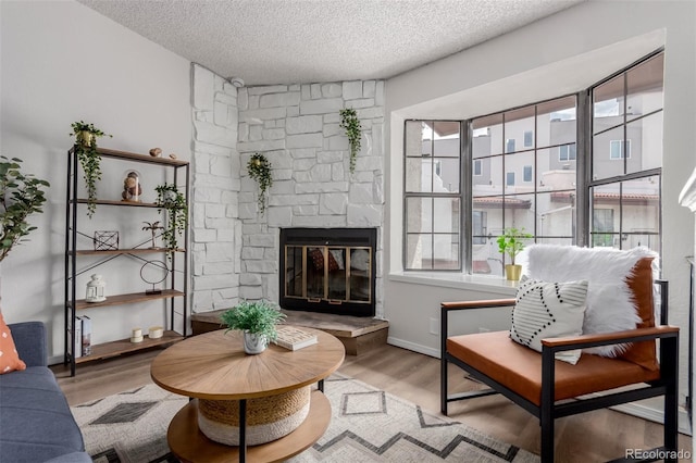 2620 S Federal Blvd Unit K, Denver, CO 80219 - living area with wood finished floors, a textured ceiling, and a fireplace