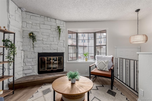 2620 S Federal Blvd Unit K, Denver, CO 80219 - sitting room with wood finished floors, a textured ceiling, and a stone fireplace