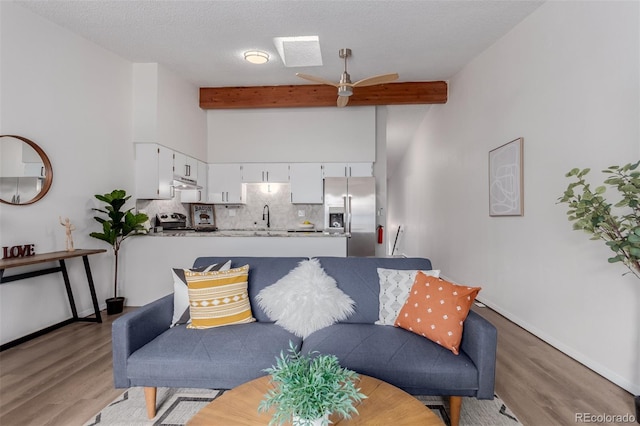 2620 S Federal Blvd Unit K, Denver, CO 80219 - living area featuring beam ceiling, light wood-type flooring, and ceiling fan