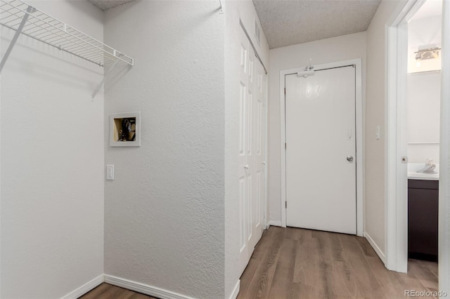 2620 S Federal Blvd Unit K, Denver, CO 80219 - laundry room featuring light wood finished floors, hookup for a washing machine, and a textured wall