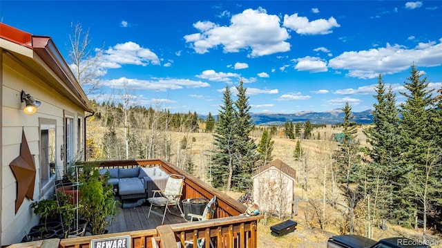 deck featuring a mountain view and an outdoor living space