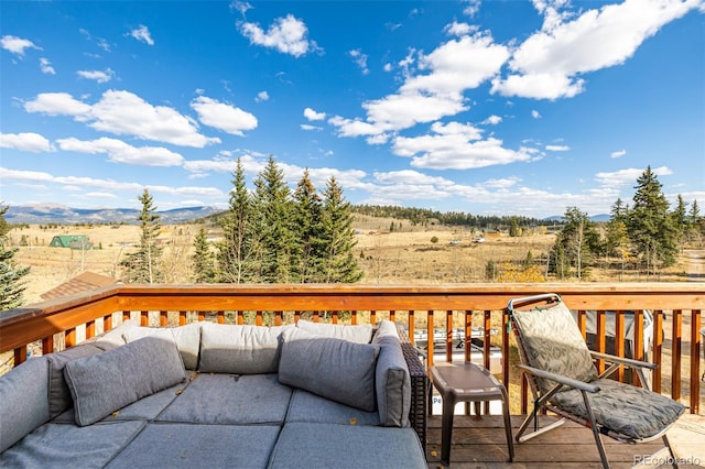 wooden terrace with a rural view and outdoor lounge area