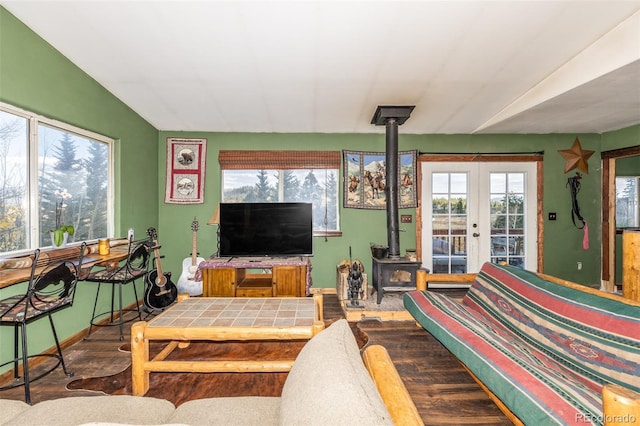 living room featuring a wood stove, lofted ceiling, hardwood / wood-style floors, and french doors