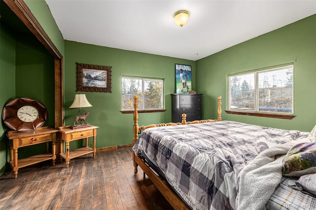 bedroom with dark hardwood / wood-style floors and multiple windows