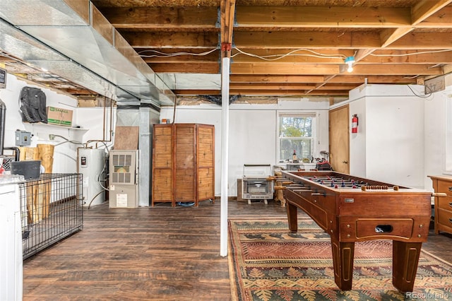 basement featuring dark hardwood / wood-style floors and electric water heater