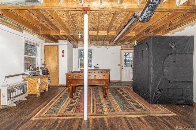 interior space with dark wood-type flooring, heating unit, and a wealth of natural light