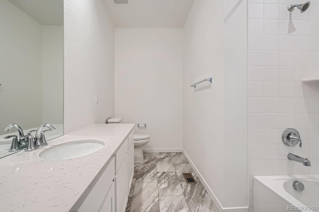 full bathroom with tiled shower / bath, vanity, and toilet