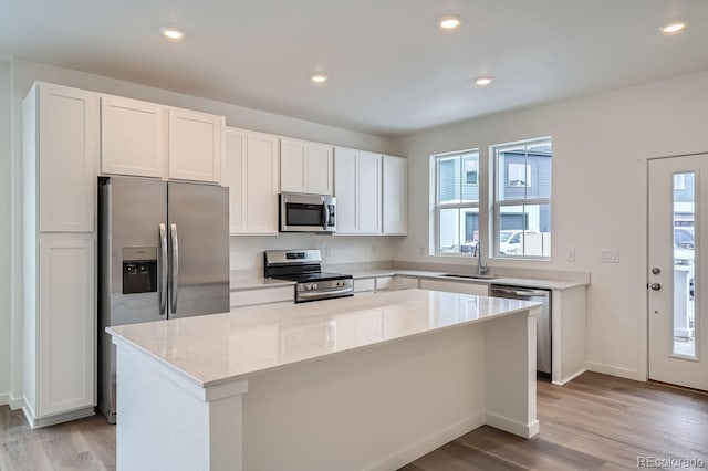 kitchen with white cabinetry, sink, a kitchen island, and stainless steel appliances