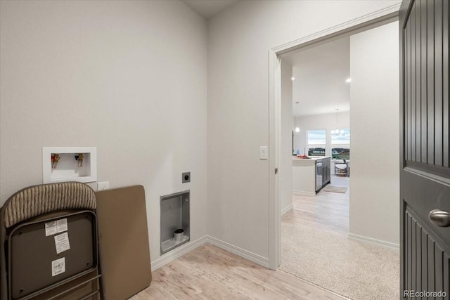 clothes washing area with hookup for an electric dryer, hookup for a washing machine, and light hardwood / wood-style flooring