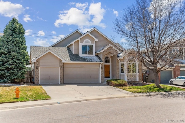 traditional-style house with roof with shingles, concrete driveway, fence, an attached garage, and brick siding
