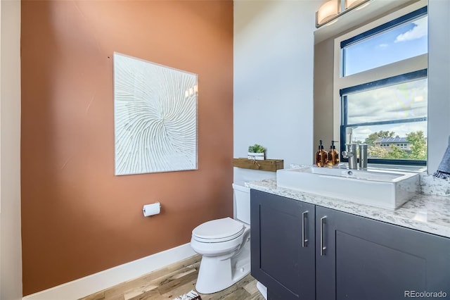 6849 E Lowry Blvd, Denver, CO 80230 - bathroom featuring toilet, wood finished floors, vanity, and baseboards
