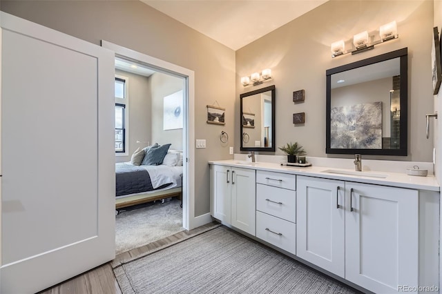 6849 E Lowry Blvd, Denver, CO 80230 - ensuite bathroom featuring wood finished floors, double vanity, and baseboards