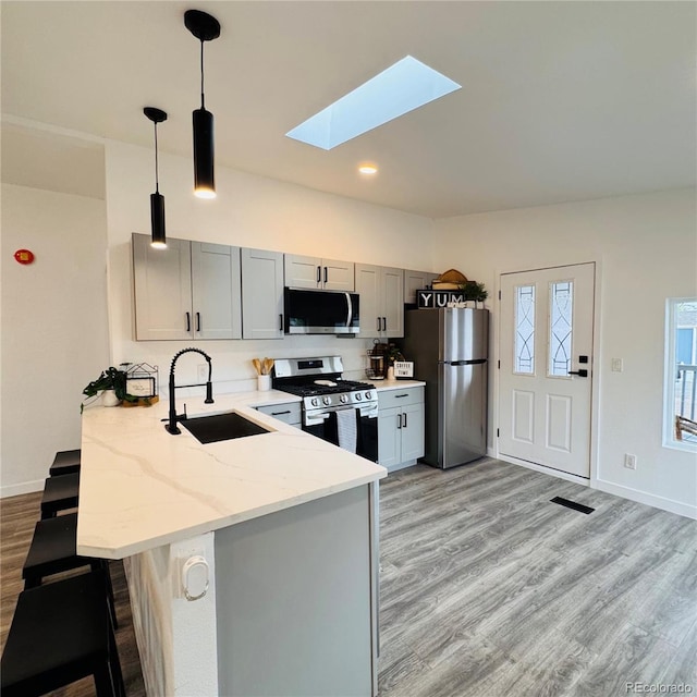 7200 E State Highway 14 Unit 27, Fort Collins, CO 80524 - kitchen featuring appliances with stainless steel finishes, a sink, a skylight, a peninsula, and light stone countertops
