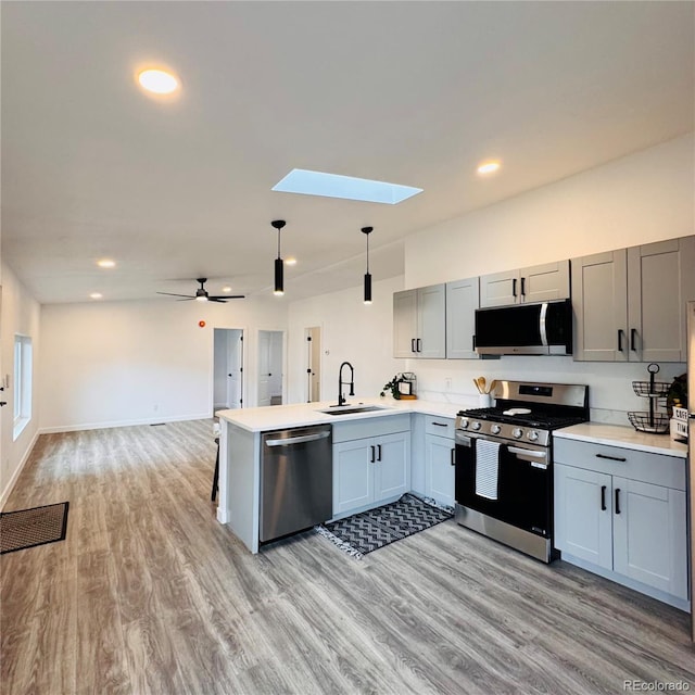 7200 E State Highway 14 Unit 27, Fort Collins, CO 80524 - kitchen with appliances with stainless steel finishes, a sink, a skylight, a peninsula, and light countertops