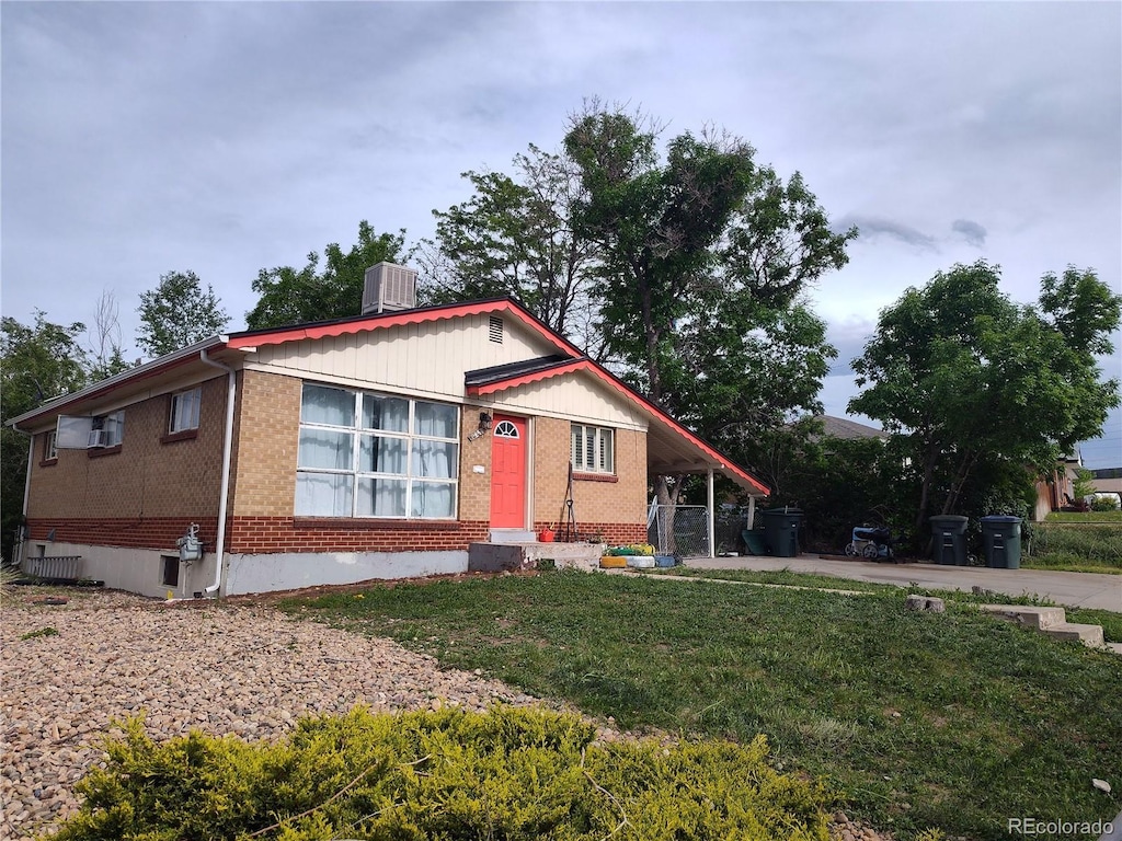 view of front of property with a front lawn and central air condition unit