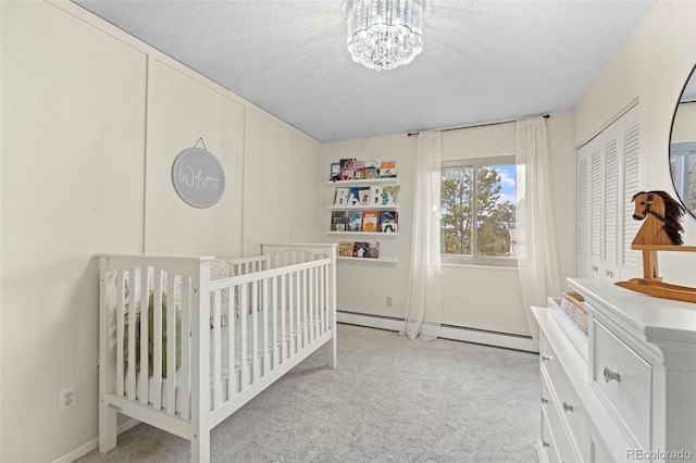 carpeted bedroom with a chandelier, a textured ceiling, a nursery area, and a closet