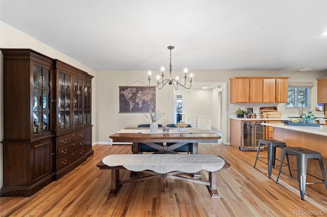 dining area with a notable chandelier, light wood-type flooring, and wine cooler