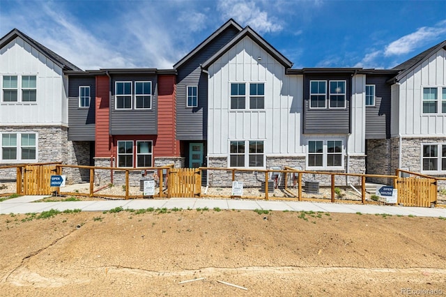 2887 E 103rd Dr, Thornton, CO 80229 - back of house featuring a fenced front yard, board and batten siding, and stone siding