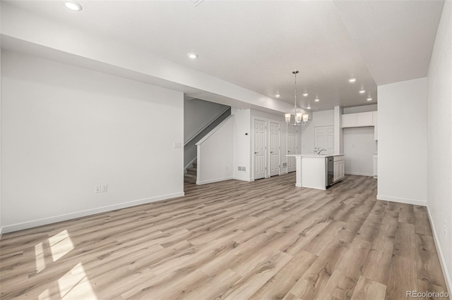 2887 E 103rd Dr, Thornton, CO 80229 - unfurnished living room featuring recessed lighting, light wood-style floors, baseboards, stairway, and a chandelier
