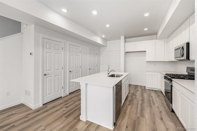 2887 E 103rd Dr, Thornton, CO 80229 - kitchen featuring appliances with stainless steel finishes, a sink, light wood finished floors, white cabinetry, and recessed lighting
