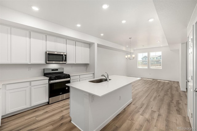 2887 E 103rd Dr, Thornton, CO 80229 - kitchen with appliances with stainless steel finishes, a sink, light wood-style flooring, a chandelier, and white cabinetry