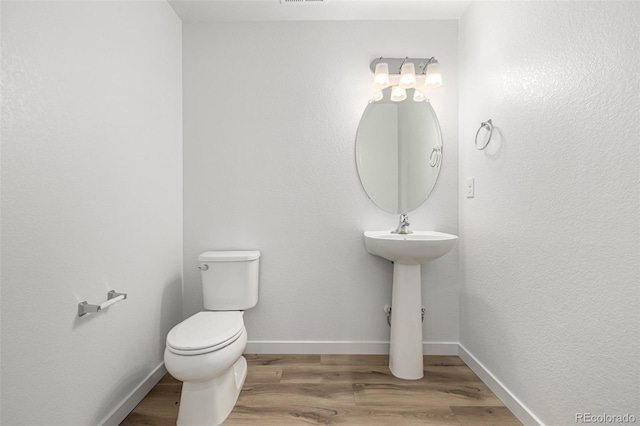 2887 E 103rd Dr, Thornton, CO 80229 - half bathroom with toilet, wood finished floors, baseboards, and a sink