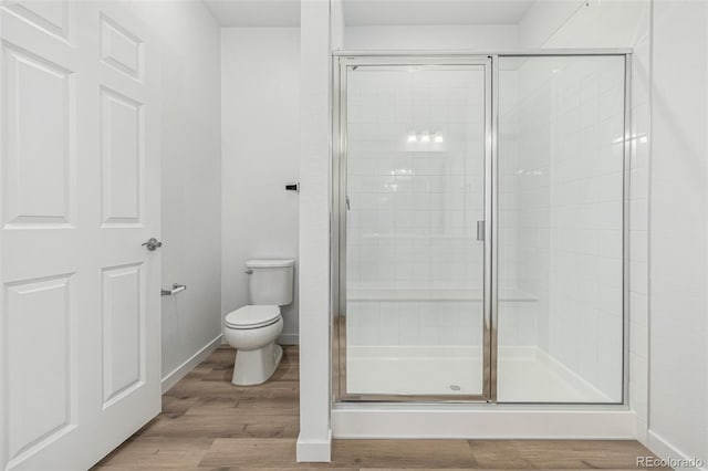 2887 E 103rd Dr, Thornton, CO 80229 - bathroom featuring a shower stall, toilet, wood finished floors, and baseboards