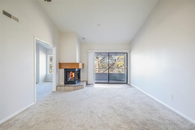 unfurnished living room featuring light carpet and high vaulted ceiling