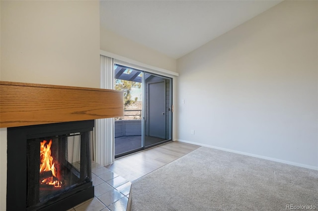 interior space with a multi sided fireplace, light carpet, and vaulted ceiling