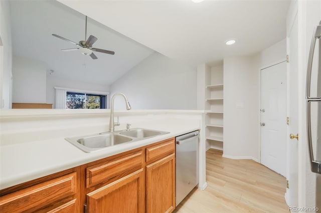 kitchen featuring sink, vaulted ceiling, stainless steel dishwasher, ceiling fan, and light wood-type flooring