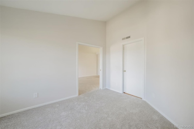 spare room featuring light colored carpet