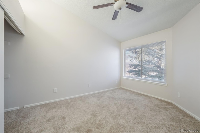 carpeted spare room with ceiling fan and lofted ceiling