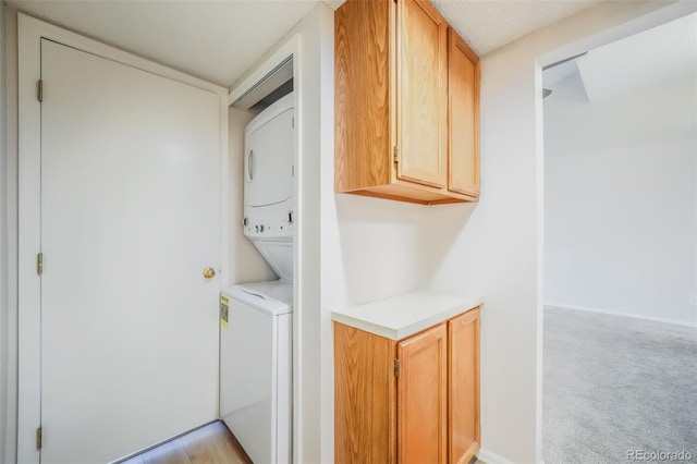 laundry area featuring light colored carpet and stacked washing maching and dryer